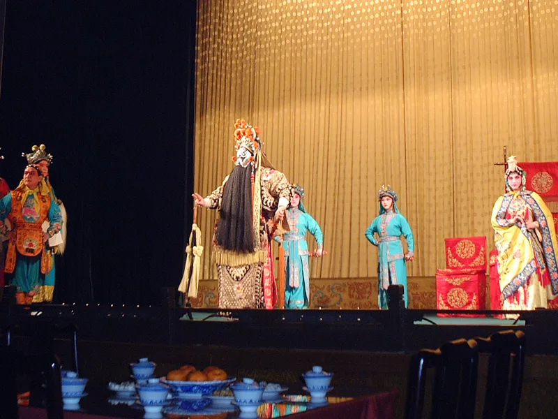 Performers in ornate Peking opera costumes on the stage at Liyuan Theatre.
