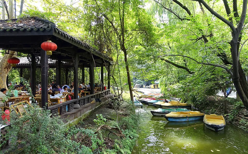 People seated around tables at an outdoor teahouse in Chengdu’s People’s Park.