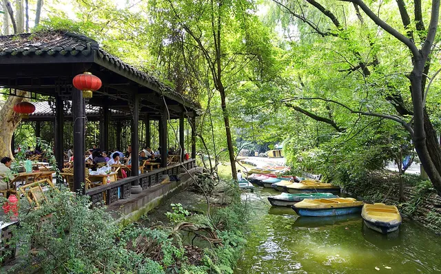 People seated around tables at an outdoor teahouse in Chengdu’s People’s Park.