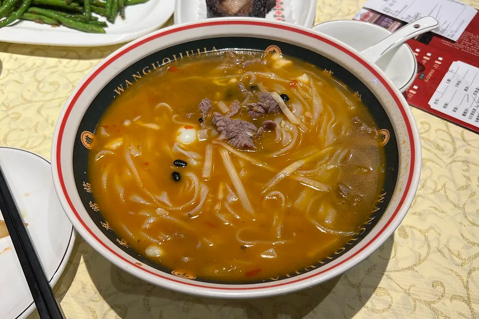 A bowl of laoyou rice noodles with beef and vegetables in Nanning.