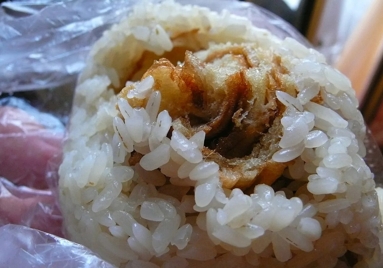 A cut-open sticky-rice roll with fried dough inside.