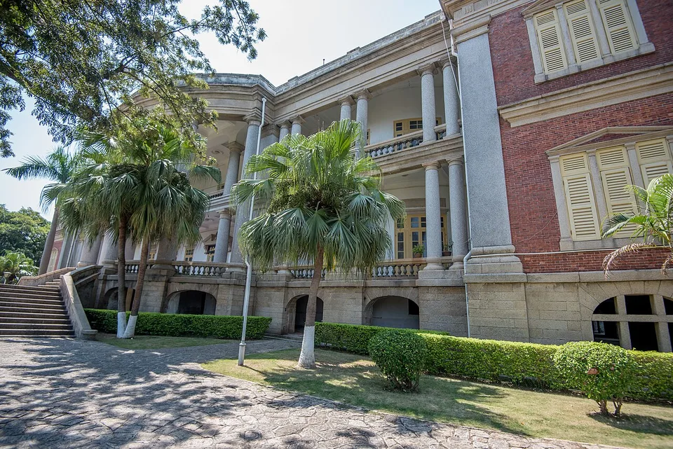 The historic facade of Bagua Mansion on Gulangyu, framed by palm trees.